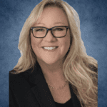 Smiling professional woman with glasses and blazer